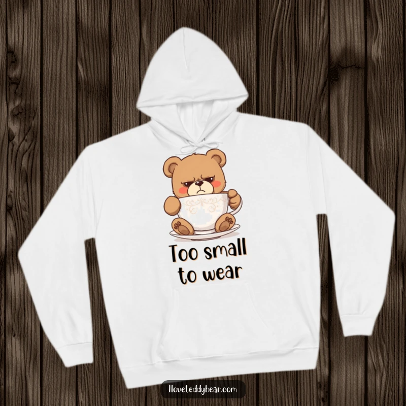 Funny hoodie with a grumpy teddy bear looking utterly stuck in a comically small teacup, conveying humorous despair. A fantastic funny gift.