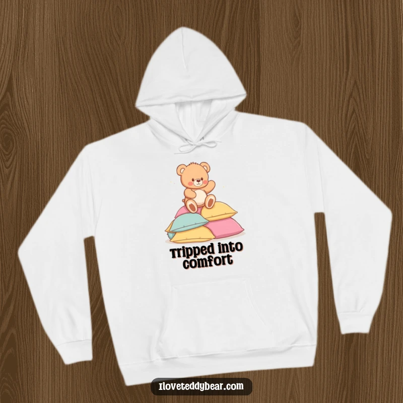 Funny hoodie with a sweet teddy bear playfully tripping onto a large heap of soft, inviting pillows, looking endearingly surprised.