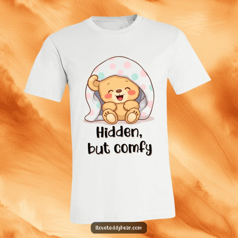 Funny T-Shirt with a cute teddy bear giggling mischievously from beneath a vibrant polka-dot blanket, radiating warmth and happiness.